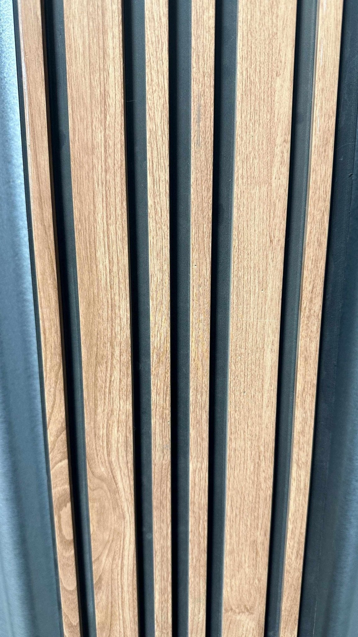 Light brown WPC wall panel with natural wood grain, black gaps, and sleek vertical stripes, available in NJ.