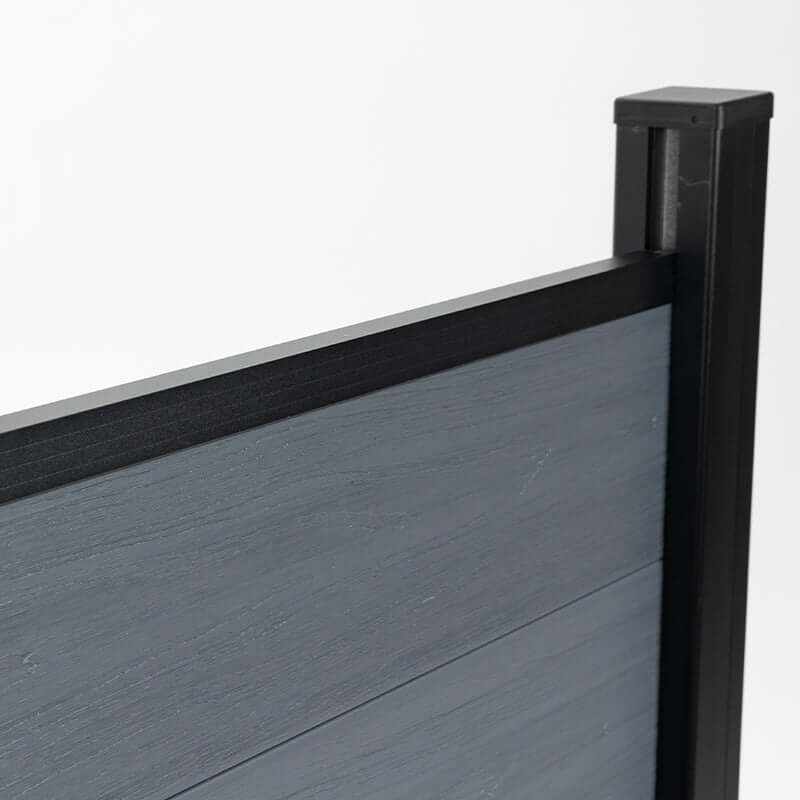 Dark gray composite fence with wood grain texture, supported by black metal posts, available at discounted prices in NJ.