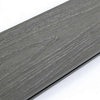 Dark gray wood grain composite deck plank with smooth, reflective finish, beveled edges, and natural knot detail in NJ.