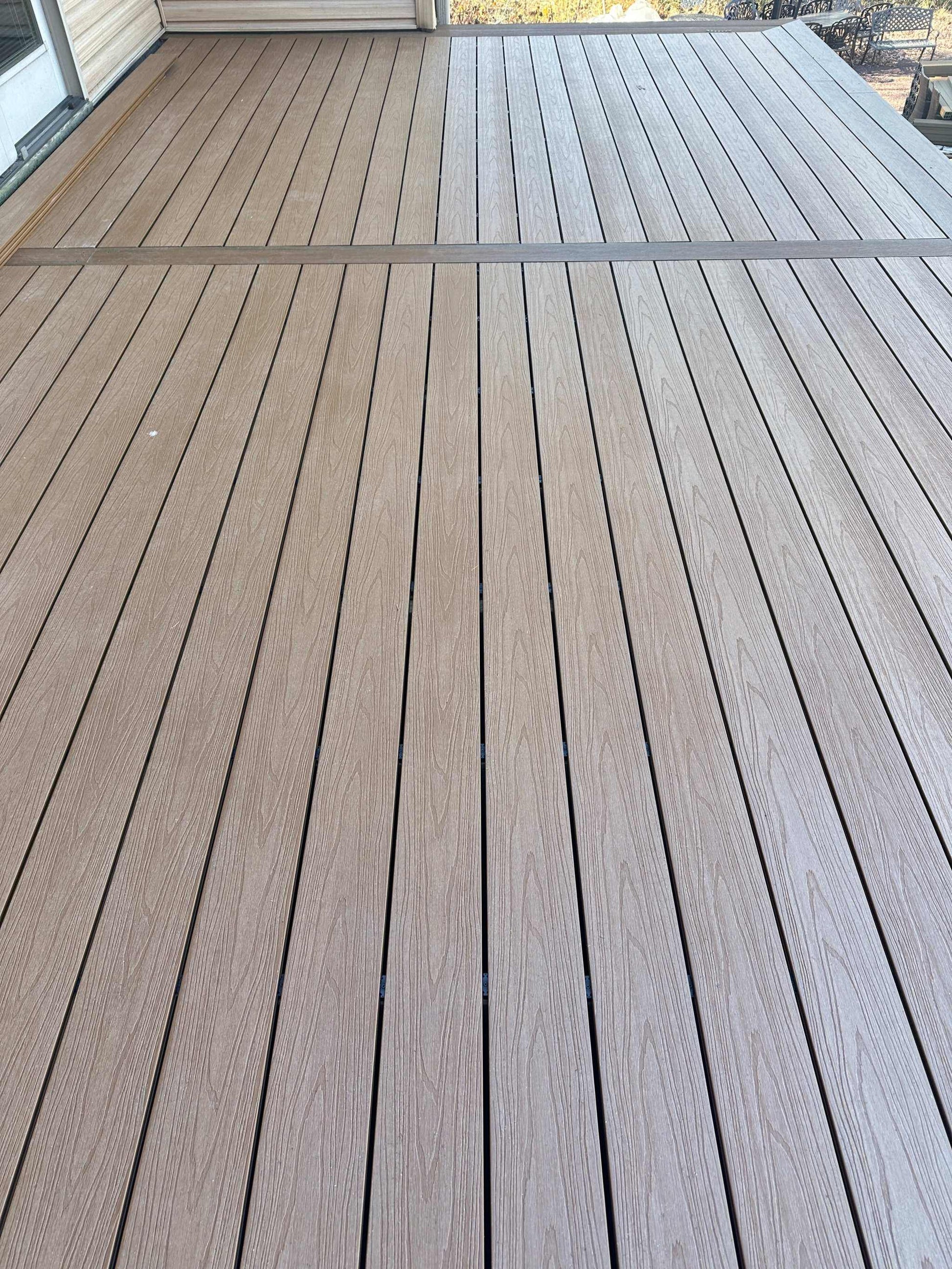 Brown walnut composite decking with grooved surface, 1x5.5x10 ft, installed on concrete slab in NJ, durable and stylish.