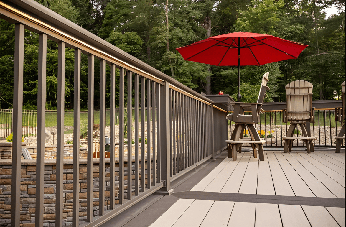 Brown composite railing kit with durable, low-maintenance design on a deck surrounded by trees in New Jersey