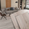 Light brown wood-like Maple Luxury SPC Flooring in a modern NJ living room with gray couch, brown chair, and natural light.